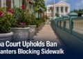 Planters beside a narrow public sidewalk representing an Aruba court ruling
