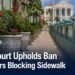 Planters beside a narrow public sidewalk representing an Aruba court ruling