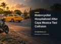 Editorial illustration of a generic taxi and motorcycle on an Aruba roadside, not a photograph of the Caya Musica collision.