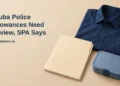 Conceptual editorial illustration of a neatly folded unbranded navy work shirt beside a blank benefits folder and a simple lunch container on a light desk, with the article headline and ArubaNews.ca branding.