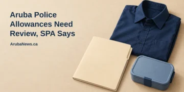Conceptual editorial illustration of a neatly folded unbranded navy work shirt beside a blank benefits folder and a simple lunch container on a light desk, with the article headline and ArubaNews.ca branding.