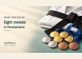 Editorial illustration of a folded white martial arts uniform, black belt and gold, silver and bronze medals, with the headline Aruba Tang Soo Do: Eight medals in Pennsylvania and ArubaNews.ca branding.