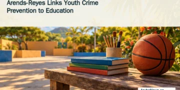 Conceptual editorial illustration of a basketball, schoolbooks and pencils beside an empty Caribbean school sports court.