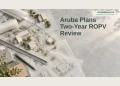 Aruba Plans Two-Year ROPV Review Editorial illustration of a planning desk with tracing sheets, ruler and neutral building blocks; not an approved plan.