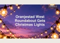 Editorial illustration of outdoor festive lights against a violet evening sky, not the actual roundabout.