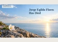 Jorge Egildo Flores Has Died Memorial editorial illustration of a white flower on stone beside a calm sea horizon.