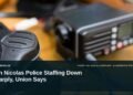 San Nicolas Police Staffing Down Sharply, Union Says Illustrative stock photo for “San Nicolas Police Staffing Down Sharply, Union Says”: Close-up of a corded radio microphone. Photo by Petr Sidorov via Unsplash; not a photograph of the specific event. Headline and ArubaNews.ca branding appear in a lower-third news tile.