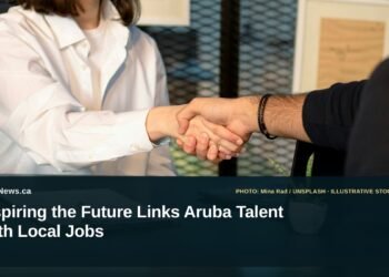 Illustrative stock photo for “Inspiring the Future Links Aruba Talent With Local Jobs”: Two people greeting across a laptop in a job interview. Photo by Mina Rad via Unsplash; not a photograph of the specific event. Headline and ArubaNews.ca branding appear in a lower-third news tile.