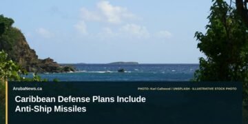 Caribbean Defense Plans Include Anti-Ship Missiles Illustrative stock photo for “Caribbean Defense Plans Include Anti-Ship Missiles”: Caribbean coastal water and rocky shoreline. Photo by Karl Callwood via Unsplash; not a photograph of the specific event. Headline and ArubaNews.ca branding appear in a lower-third news tile.