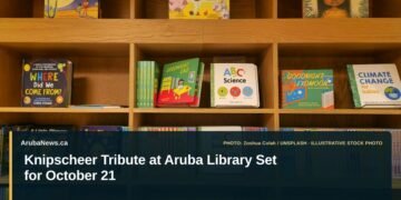 Knipscheer Tribute at Aruba Library Set for October 21 Illustrative stock photo for “Knipscheer Tribute at Aruba Library Set for October 21”: Children’s books arranged on library shelves. Photo by Zoshua Colah via Unsplash; not a photograph of the specific event. Headline and ArubaNews.ca branding appear in a lower-third news tile.
