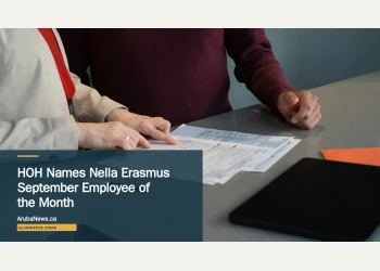 Illustrative stock photograph for “HOH Names Nella Erasmus September Employee of the Month”: Two professionals reviewing paperwork at a conference table during a business meeting in San Francisco. Photograph by Olena Kholina via Unsplash. This is not a photograph of the specific Aruba news event.