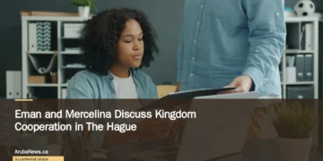 Eman and Mercelina Discuss Kingdom Cooperation in The Hague Illustrative stock photograph for “Eman and Mercelina Discuss Kingdom Cooperation in The Hague”: Colleagues reviewing papers; illustrative stock, not the reported meeting. Photograph by Vitaly Gariev via Unsplash. This is not a photograph of the specific Aruba news event.