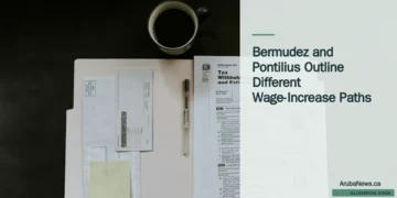 Illustrative stock photograph for “Bermudez and Pontilius Outline Different Wage-Increase Paths”: Tax forms, a pen, and a coffee mug on a dark desk Photograph by Kelly Sikkema via Unsplash. This is not a photograph of the specific Aruba news event.