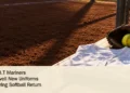 Conceptual editorial illustration of an unbranded softball jersey, glove and ball on a dugout bench; not a photograph of the S.B.T Mariners.