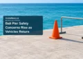 Conceptual editorial still life of a plain traffic cone and unmarked barrier beside water; not a photograph of Bali pier or evidence of its condition.