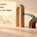 Conceptual editorial illustration of two different wooden arches connected by curved blue glass, with the article headline and ArubaNews.ca branding; not an actual building or project design.