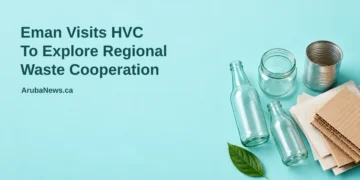 Conceptual editorial illustration of sorted recyclable glass, cardboard and a metal can, not an actual HVC facility or proposed plant, with the regional waste cooperation headline and ArubaNews.ca branding.