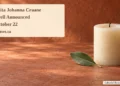 Floresita Johanna Craane Farewell Announced for October 22 Conceptual memorial illustration of an unlit cream candle and green leaf on a terracotta tabletop, with the article headline and ArubaNews.ca branding; not a photograph of the person or funeral.