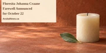 Conceptual memorial illustration of an unlit cream candle and green leaf on a terracotta tabletop, with the article headline and ArubaNews.ca branding; not a photograph of the person or funeral.