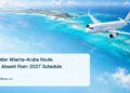 Conceptual editorial illustration of an unbranded passenger aircraft above turquoise Caribbean waters, with a Frontier route headline and ArubaNews.ca branding.