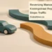 Conceptual miniature illustration of a generic model car and two separate curved road shapes, not the actual vehicle or junction, with the article headline, ArubaNews.ca branding and editorial-illustration label.