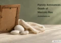 Conceptual memorial illustration of the plain back of an empty wooden frame, white pebbles and folded linen, with the article headline and ArubaNews.ca branding; no portrait of Marcelo Ras.