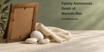 Family Announces Death of Marcelo Ras Conceptual memorial illustration of the plain back of an empty wooden frame, white pebbles and folded linen, with the article headline and ArubaNews.ca branding; no portrait of Marcelo Ras.