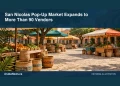 Conceptual editorial illustration: An empty colorful outdoor craft market with woven baskets, produce and shaded stalls on a generic Caribbean square, lively terracotta and green, wide street-level perspective. No signs, prices, people, real buildings or logos. Not a photograph of the actual event, people or location.