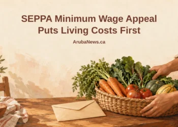 Conceptual editorial illustration of a worker’s hands arranging a modest basket of vegetables and an unmarked pay envelope on a kitchen table, with the article headline and ArubaNews.ca branding.