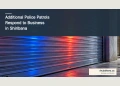 Conceptual editorial illustration of blue and red light reflected on an unmarked storefront shutter; not an image of the Shiribana business or incident.